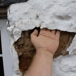 The plastic paint was blistering and detaching itself from the stonework as seen here. The stonework behind the paint was becoming friable and the mortar joints were crumbling!
This is a good example of why modern plastic paints should not be applied over historic fabric. The plastic paint had to be painstakingly removed from the whole elevation! To save excessive repointing a lime/aggregate slurry mix was applied over deep areas to act as a key for the new limewash.