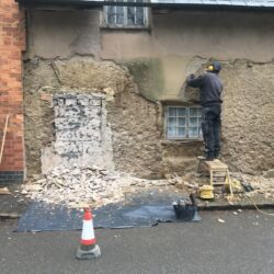 Removing the cement rendering exposed a blocked doorway , possibly from when the house was two dwellings.