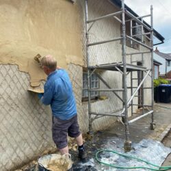 The floating coat render being applied onto the damp scratch coat.