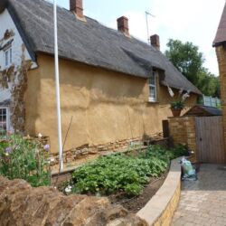 Two coats of lime render were applied onto the cob and followed the contours of the wall. The stone plinth remains exposed and will be pointed in lime mortar.