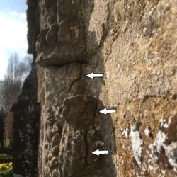 The decorative feature beneath the hooded niche was detaching and cracked, areas highlighted by white arrows.
