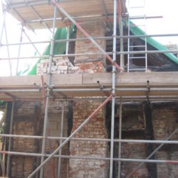 The end elevation of the house mid project! All the brick panels have been removed and the cement render has been removed from the brick chimney stack. The majority of the timbers in the photo have still to be taken out as they were too rotton to leave in place